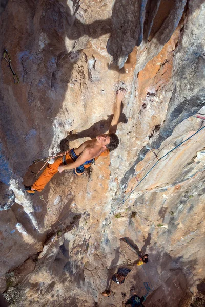 Top View of Rock Climber on orange Vertical Wall