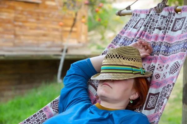 Person lying in Hammock at Patio of Wooden Rural Cottage