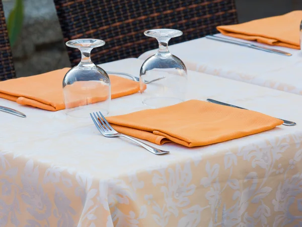 Restaurant table prepared with damask  table cloth orange napkin