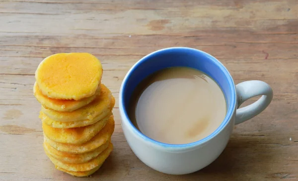 Milk coffee and mini pancake on table