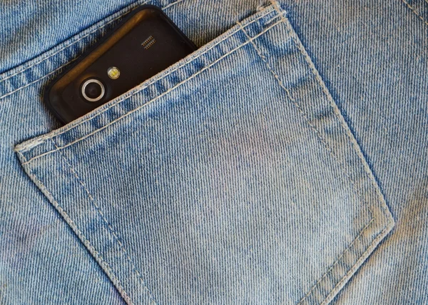 Mobile phone in blue jean back pocket