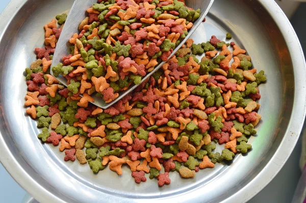 Pet food in scoop on weighing scale tray