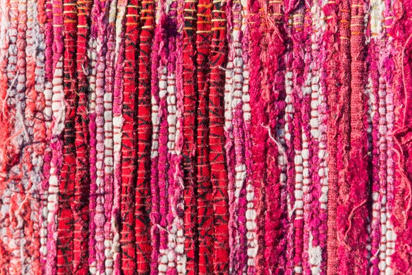 Texture of woven cotton red, pink, white threads