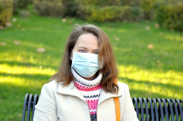 Woman in a medical mask on nature