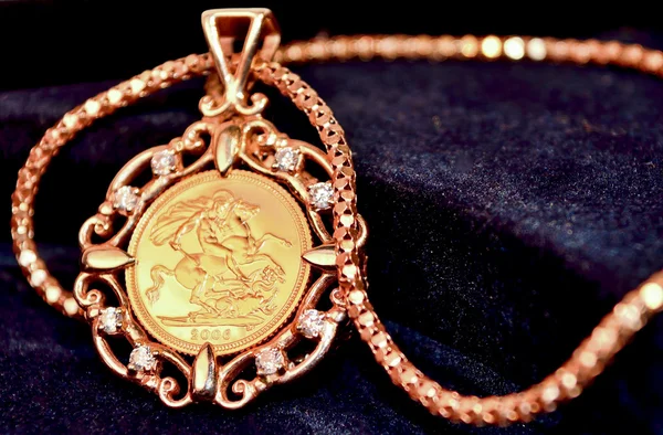 Gold sovereign coin as woman\'s jewelry pendant on a chain