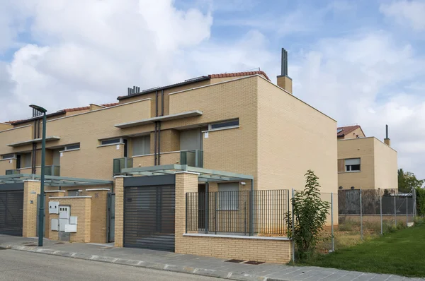 Facade of a modern architecture brick house with fence, window, balcony and metal porch