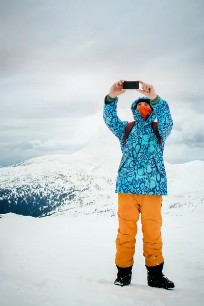 Man taking selfie with smartphone on mountains background