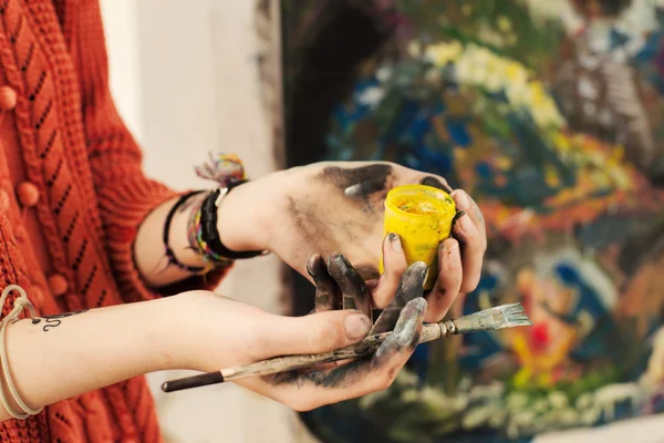 Brushes and oil paints in woman hands