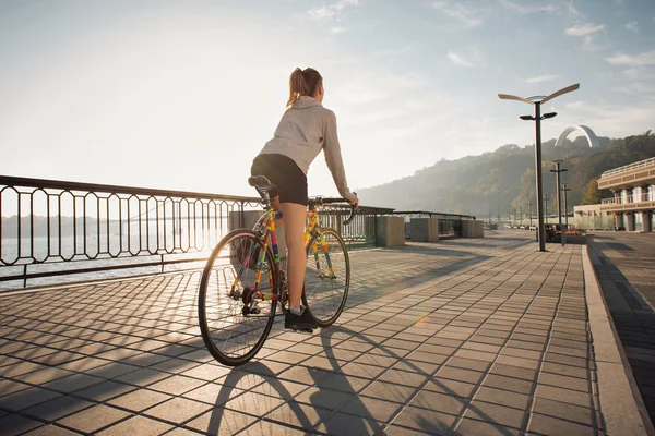 Young woman cycling in the morning city