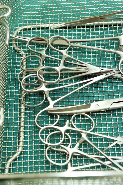Detail shot of steralized surgery instruments with a hand grabbing a tool