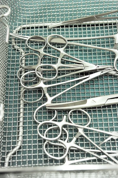 Detail shot of steralized surgery instruments with a hand grabbing a tool