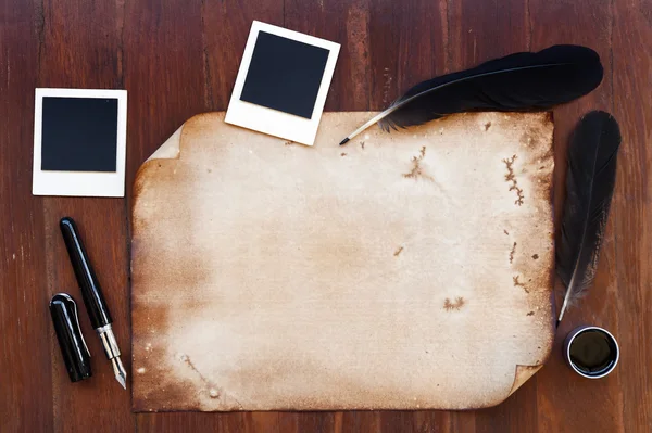 Old paper with feather, pen and photo frame