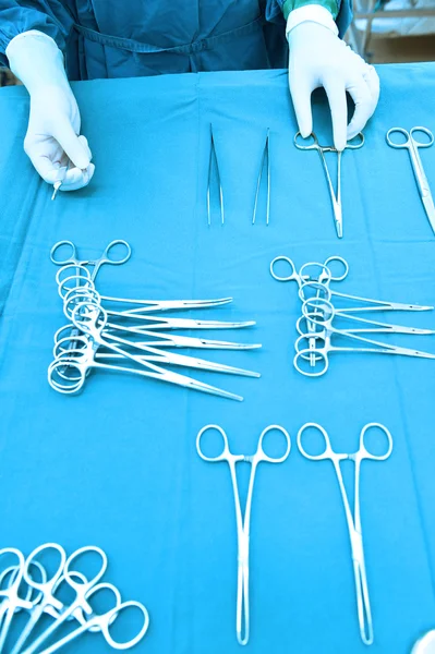 Detail shot of steralized surgery instruments with a hand grabbing a tool