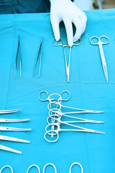Detail shot of steralized surgery instruments with a hand grabbing a tool
