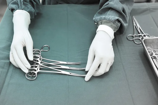 Detail shot of steralized surgery instruments with a hand grabbing a tool