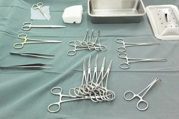 Detail shot of steralized surgery instruments with a hand grabbing a tool