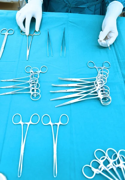 Detail shot of steralized surgery instruments with a hand grabbing a tool