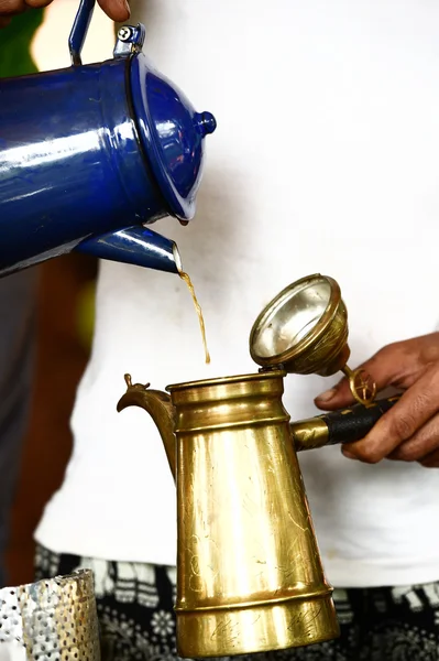 Hand pouring freshly brewed coffee