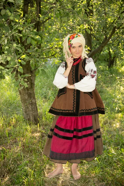 Young girl, Ukrainian national costume, standing barefoot on the