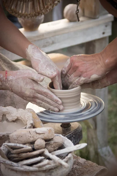 Hands in the clay, four hands molded clay, the clay on a potter\'