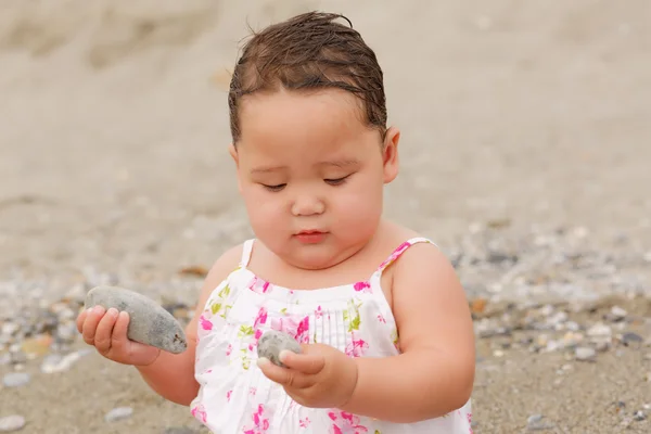 Pretty little girl in pink dress on the beach