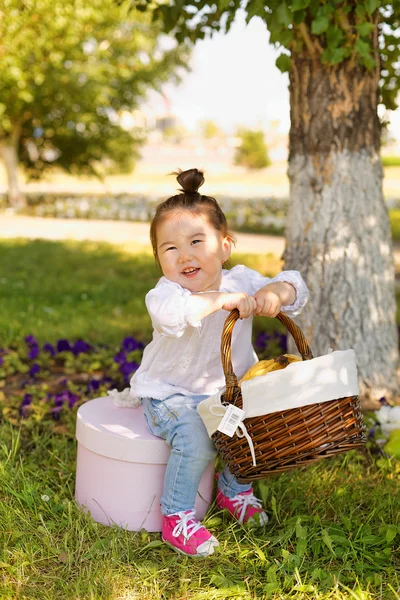 Beautiful little girl with flowers and basket