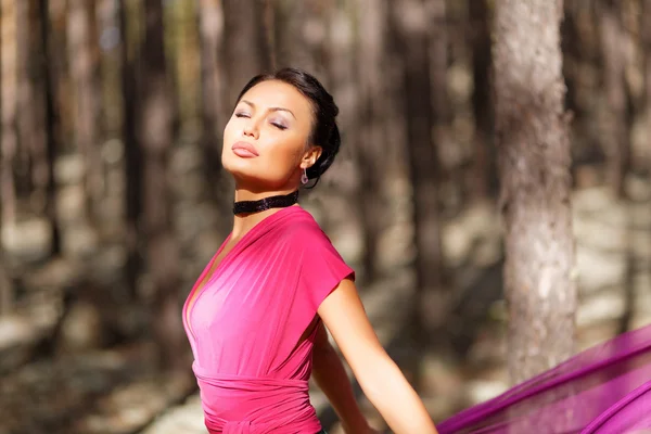 Beautiful kazakh woman in trendy dress in the forest