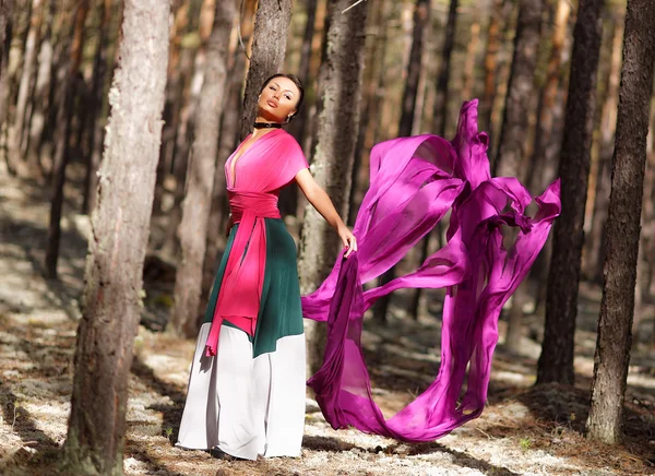 Beautiful kazakh woman in trendy dress in the forest