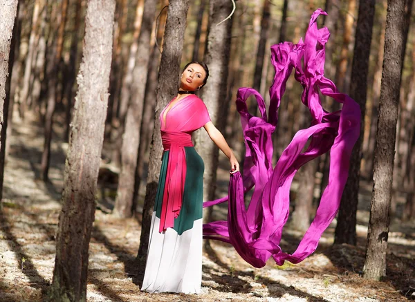 Beautiful kazakh woman in trendy dress in the forest