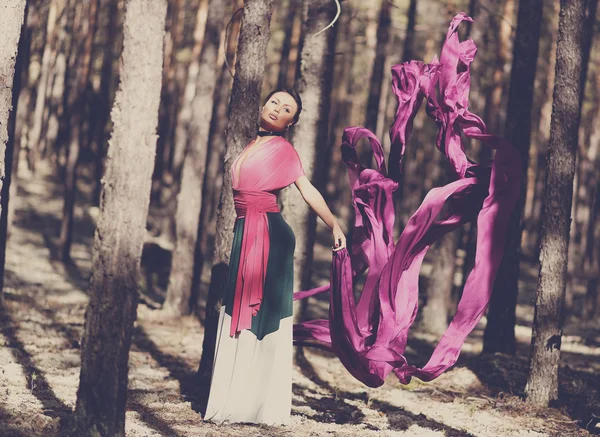 Beautiful kazakh woman in trendy dress in the forest