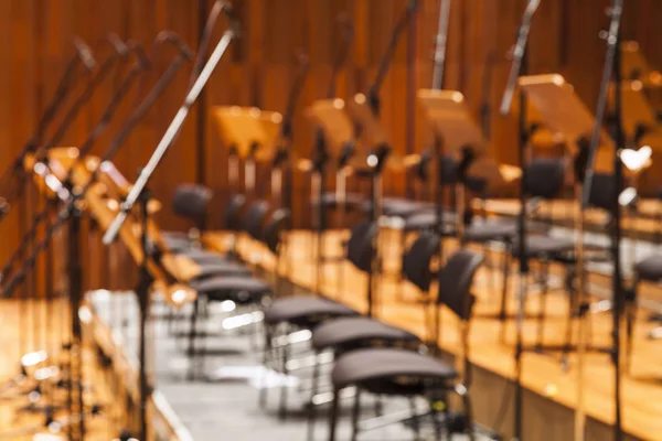 Blurred Orchestra stage with chairs and microhone as Background