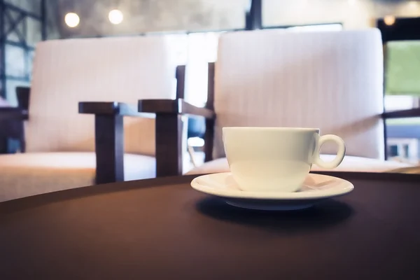 Coffee cup on table with seats in Cafe restaurant