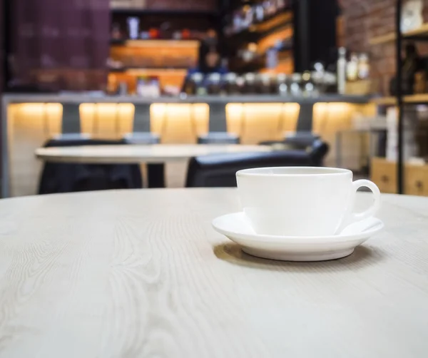 Coffee cup on table with blurred counter Bar Cafe restaurant backgroud