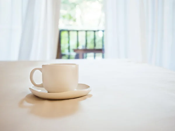 Coffee cup on table Home interior with curtain and terrace Background