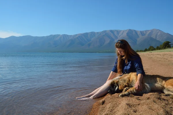 Girl with a dog on the shore of Lake Baikal