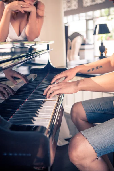 A man plays the girl on the piano