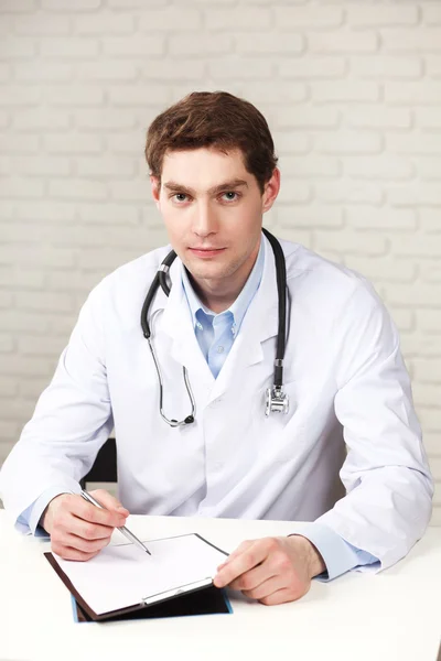 Young doctor sitting in medical office