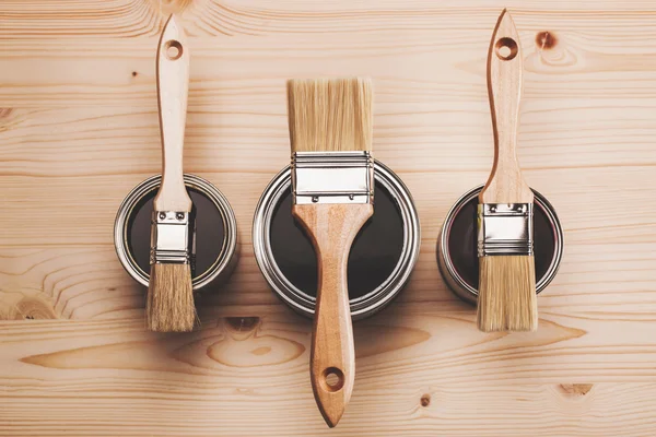 Paint brushes on three cans