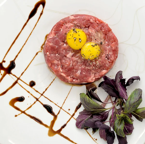 Steak Tartar. Ground beef and raw egg with herbs and spices on a