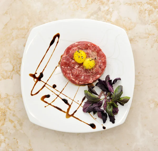 Steak Tartar. Ground beef and raw egg with herbs and spices on a