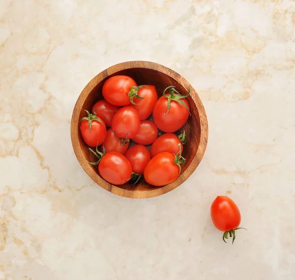 The cherry tomatoes in a wooden bowl