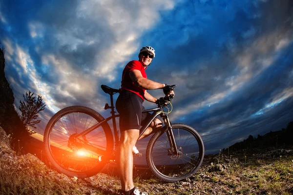 Mountain bicycle rider on the hill with sunrise background