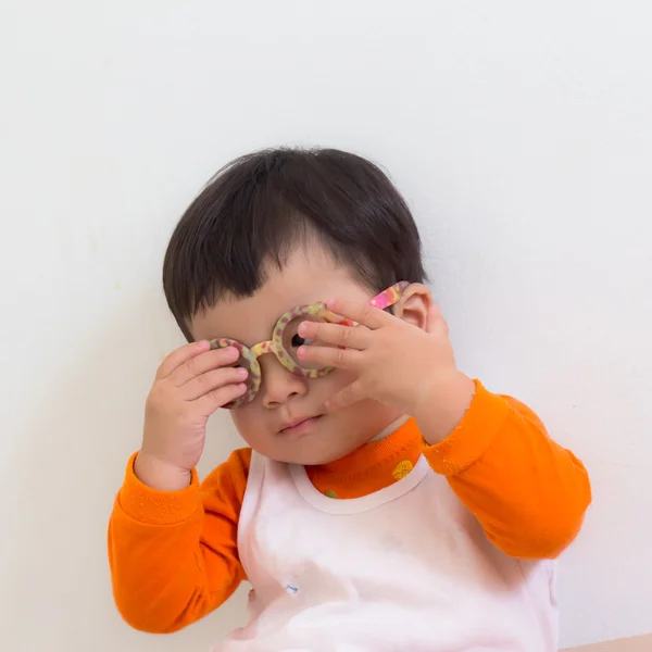 Asian boy wearing glasses, but hand off face.