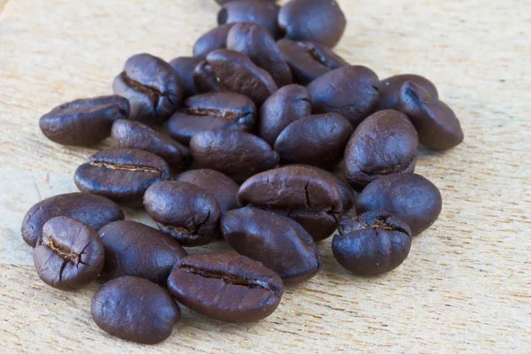 Raw coffee beans lying on a wooden table top