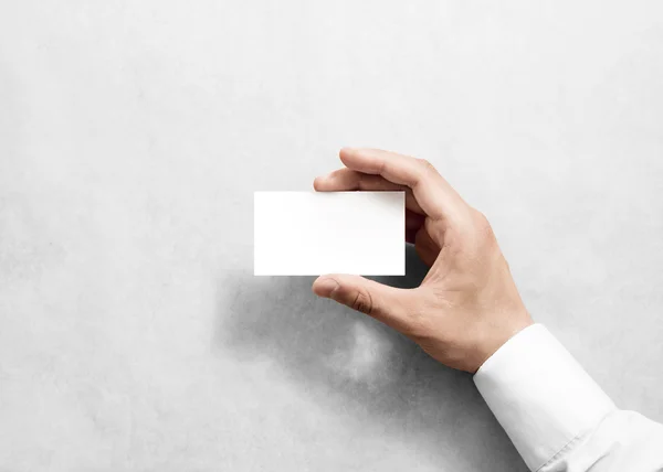 Hand holding blank white business card design mockup.