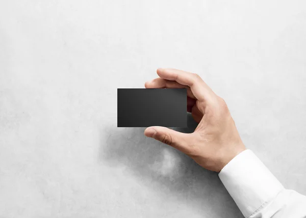 Hand hold blank plain black business card design mockup.