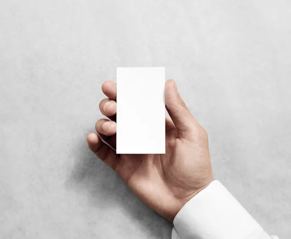 Hand holding blank vertical white business namecard mock up.