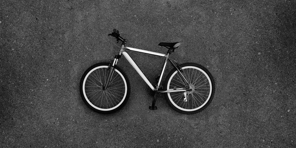 Super large photo of bike bycicle on the pavement. Bicycle in black and white color. Real asphalt texture background. Best way show postcard with this velo. Velocipede on grey asphault textured surface.