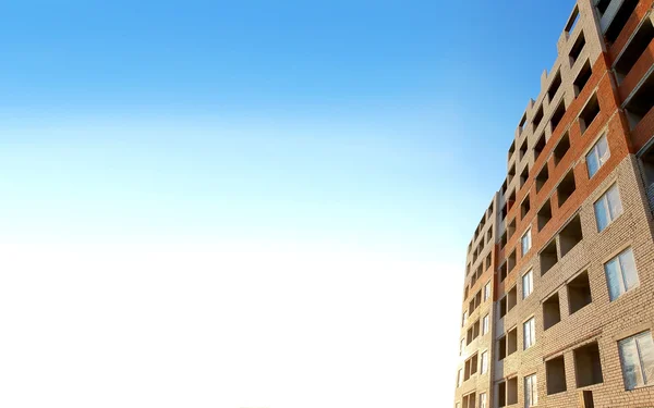 Big photo house building architecture brick surface. Block wall window, under construction. Blue sky background. Built home city concrete exterior developement. Brickwall background texture apartments