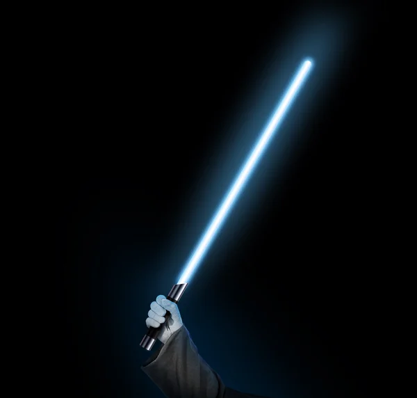 Blue light saber holdng in hand isolated on black.